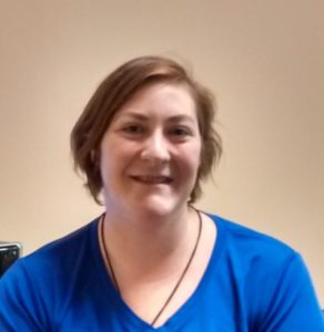 Smiling massage therapist in an office that offers both chiropractic and massage.